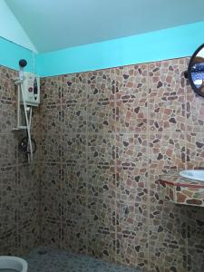 a bathroom with a stone wall with a sink at No Name Bungalow Haad Yao in Haad Yao