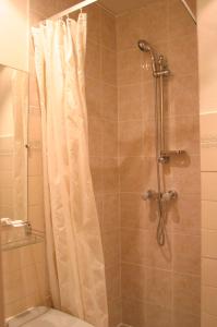 La salle de bains est pourvue d'une douche avec rideau de douche. dans l'établissement Printania Porte de Versailles, à Paris