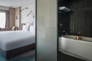 a hotel room with a bed and a bath tub at Pullman Zhouzhuang in Kunshan