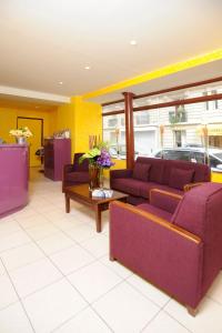 a living room with purple couches and a table at Printania Porte de Versailles in Paris