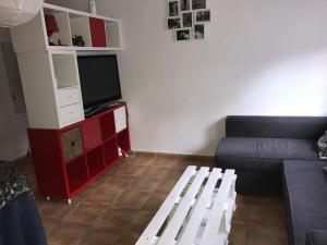 Una sala de estar con un sofá y un televisor. en El Río, en Arroyo Frío