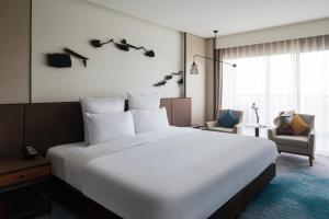 a large white bed in a hotel room at Pullman Zhouzhuang in Kunshan