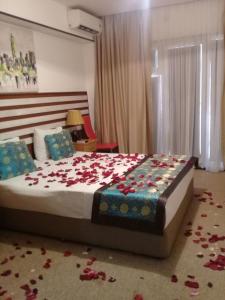 1 dormitorio con 1 cama con rosas en el suelo en Gallery Hotel Baku en Bakú