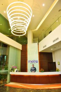 a man standing in a lobby with a large chandelier at Metro Hotel Bukit Bintang in Kuala Lumpur