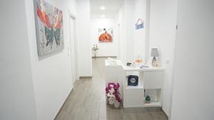 a hallway with white walls and a white table with flowers at Bed & Breakfast Tramonti in Trapani