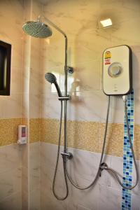 een douche met een glazen deur in de badkamer bij The House at Pranburi in Pran Buri