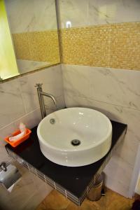 een badkamer met een witte wastafel en een spiegel bij The House at Pranburi in Pran Buri