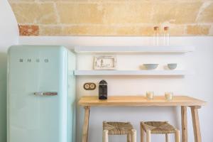 a small table with stools next to a refrigerator at Holiday Home Casa Sa Font by Mauter Villas in Ciutadella