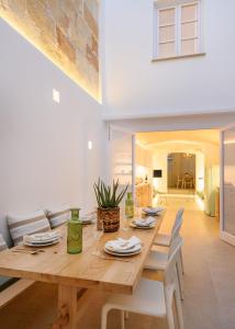 uma sala de jantar com uma mesa de madeira e cadeiras brancas em Holiday Home Casa Sa Font by Mauter Villas em Ciutadella