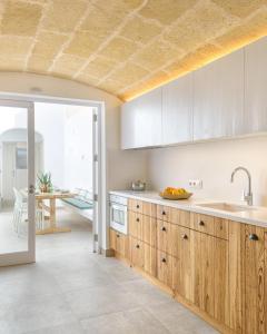 シウタデリャにあるHoliday Home Casa Sa Font by Mauter Villasのキッチン(木製キャビネット付)が備わり、パティオの景色を望めます。