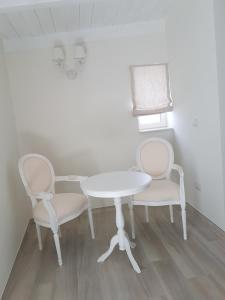 un tavolo con due sedie e un tavolo e sedie bianchi di Finestre sul Borgo a Cassano delle Murge