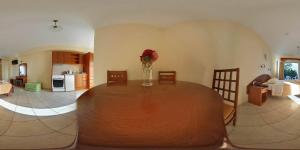 a living room with a wooden table with a vase of flowers at Kosmos Hotel in Agios Stefanos