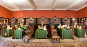 Pokój z zielonymi stołami i krzesłami oraz pomarańczowymi ścianami w obiekcie Chateau de Raissac w Béziers