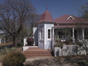 ein kleines weißes Haus mit rotem Dach in der Unterkunft Melville Turret Guesthouse in Johannesburg