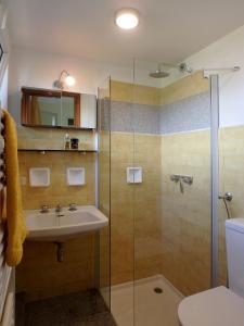 La salle de bains est pourvue d'un lavabo et d'une douche. dans l'établissement Casa Laluni, à Porto Valtravaglia