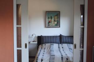 ポルト・ヴァルトラヴァーリアにあるCasa Laluniのベッドルーム1室(ベッド1台付)が備わります。壁に絵が飾られています。