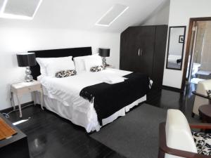 a bedroom with a bed with white sheets and pillows at Melville Turret Guesthouse in Johannesburg