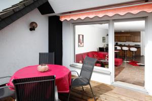 a dining room with a red table and chairs at Ferienwohnung Inge Steinrücken in Winterberg