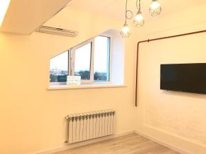 a living room with a flat screen tv and a radiator at Scandik Apartment Terrace in Poltava