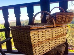 two wicker baskets sitting on a porch with a view at Pousada Lua e Sol in Santo Antônio do Pinhal