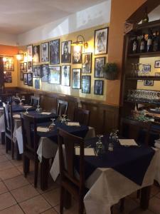 a dining room with blue tables and photos on the wall at Gil's Hotel in Olbia