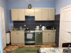 a kitchen with white cabinets and a stove top oven at Jasi Stay in Augustów