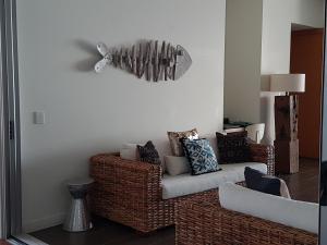 a living room with a couch and a surfboard on the wall at Penthouse on Bright Point in Nelly Bay