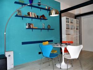 a table and chairs in a room with a blue wall at 4effe Home in Sestri Levante