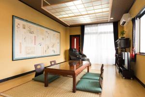 a room with a table and chairs and a tv at Kyoto Matsuya in Kyoto