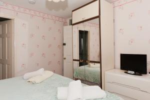 a bedroom with a bed with a mirror and a tv at Birtley House Guest House B&B in Telford