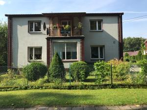 a house with a balcony with flowers on it at Jasi Stay in Augustów