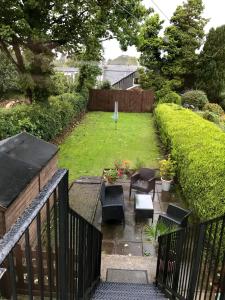 a backyard with a garden with chairs and a fence at In House Garden Flat in Castle Douglas