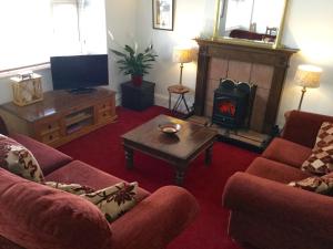 a living room with two chairs and a fireplace at In House Garden Flat in Castle Douglas