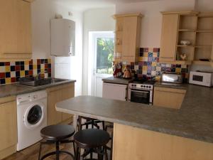 a kitchen with a counter and two bar stools at In House Garden Flat in Castle Douglas