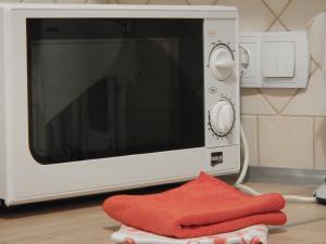 a microwave oven with a red towel next to it at Traugutta apartment in Wrocław