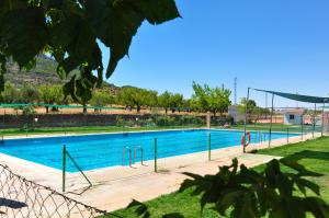 una gran piscina con agua azul en un parque en Casa Rural Los Montones, en Carcelén