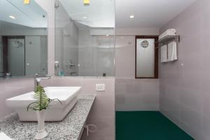 bagno con lavandino bianco e pavimento verde di Oasis Kathmandu Hotel a Kathmandu