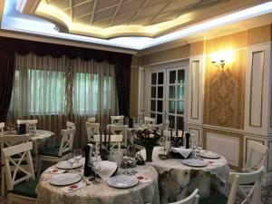 un comedor con mesas blancas y sillas blancas en Romantic Boutique, en Focşani