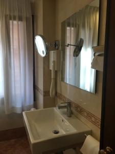 
a bathroom with a sink, mirror and bathtub at Royal San Marco Hotel in Venice
