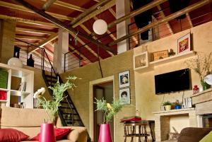 ein Wohnzimmer mit einem Sofa, einem TV und einem Kamin in der Unterkunft Casa Rural Mirador del Sol in Villalba del Alcor