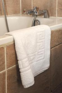 - une serviette blanche suspendue sur le côté d'une baignoire dans l'établissement Auriane Porte De Versailles, à Paris