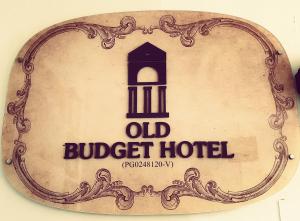 an old bucket hotel sign on a wall at Old Budget Hotel in George Town