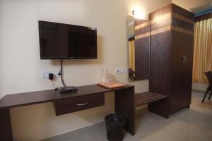 Una habitación con un escritorio y un televisor de pantalla plana. en S4 Residency, en Chennai