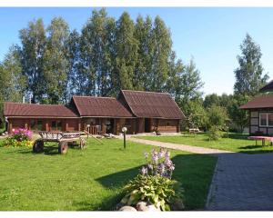 a log cabin in a park with a bench and flowers at Agrousadba Domik na vyhodnye in Gamzelëvo