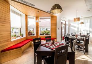 a dining room with tables and chairs and windows at Horeum Boutique Hotel in Sibiu