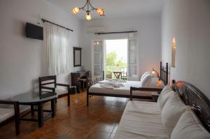 a living room with a couch and a table at Yperia Hotel in Aegiali +37 photos