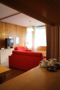 ボルミオにあるAppartamento EIRAのリビングルーム(赤いソファ、赤い椅子付)