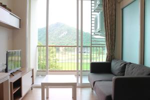 a living room with a couch and a large window at Baan Khao Yai in Pak Chong