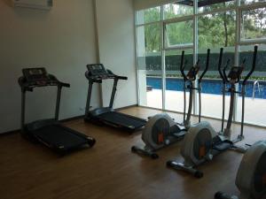 - une salle de sport avec 4 vélos d'exercice dans une pièce dotée d'une fenêtre dans l'établissement Baan Khao Yai, à Pak Chong