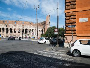 una calle de la ciudad con coches aparcados frente a un edificio en Domus Claudi Colosseum, en Roma